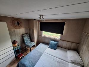 a bedroom with a bed and a window and a chair at Villa Berk en Heide in Rosmalen