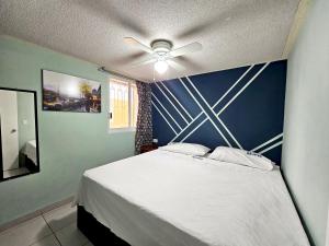 提瓦坎的住宿－Sensity Home Dpto céntrico hermoso y cómodo，一间卧室配有一张带吊扇的床