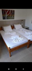 ein großes Bett mit weißer Bettwäsche und Kissen darauf in der Unterkunft ERA Studios in Skiathos-Stadt