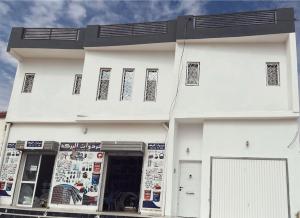 a white building with a sign in front of it at Appartement de luxe avec un toit terrasse in Nouakchott