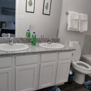 a bathroom with two sinks and a toilet at Maison EMN in Fort Worth