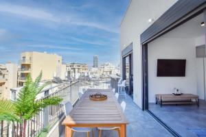 a balcony with a table and a view of a city at Marine Pearl by HolyGuest in Tel Aviv