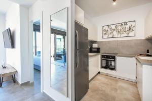 a kitchen with a stainless steel refrigerator in a room at Marine Pearl by HolyGuest in Tel Aviv