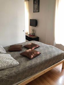 uma cama com quatro almofadas num quarto em Mon Paris em Paris