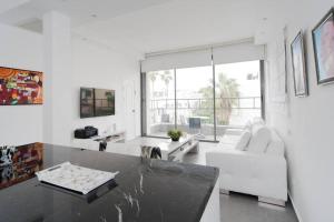 een witte woonkamer met een witte bank en een tafel bij Pearl & Caviar by Holyguest in Tel Aviv