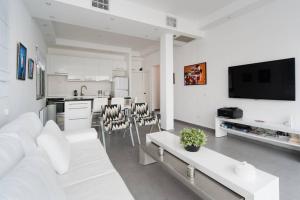 een witte woonkamer met een witte bank en een keuken bij Pearl & Caviar by Holyguest in Tel Aviv