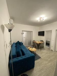 - un salon avec un canapé bleu et une table dans l'établissement Apartman Blagojevic, à Veliko Gradište