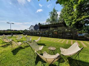 a group of chairs and tables on the grass at BREZA mobile house BIG BERRY in Metlika