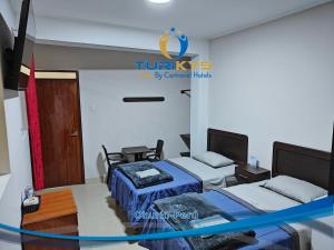Zimmer mit 2 Betten und einem TV. in der Unterkunft Hotel Turikys Churin in Churín