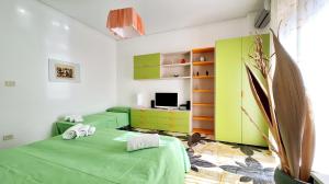 a bedroom with two green beds and a tv at Casa Iolanda in Riposto +40 photos