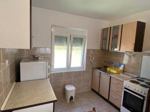 a kitchen with a white refrigerator and a sink at Apartman LUCIJA, dostupan minimum 7 NOCENJA i VISE, AVAIBLE FOR RENT MINIM 7 NIGHTS AND MORE in Sutomore