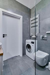 een badkamer met een wasmachine en een toilet bij Apartament Sztuk Pięknych 4 in Piła