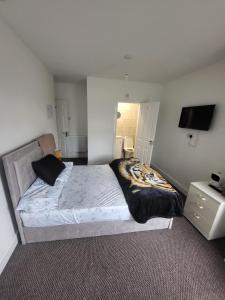 a bedroom with a large bed and a television at UNIVERSITY HOMES in Middlesbrough
