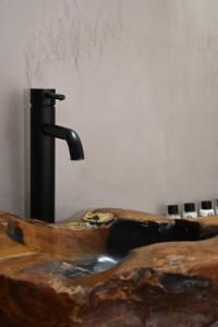 uma banheira de madeira com torneira de água em Αιγιαλίς - Πολυτελη διαμερισματα em Caristo