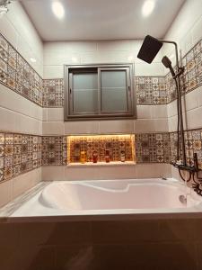 a large white tub in a bathroom with a window at 2 bedrooms Smart Home 5m drive to the Sea in Nabeul