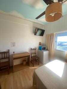 a bedroom with a bed and a desk and a window at Habitación frente al mar in Mar del Plata