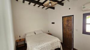 um quarto com uma cama e uma porta de madeira em La Merced em Salta