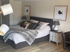 a bedroom with a large bed with two lamps and a table at agréable chambre d hôte avec piscine et jacuzzi in Thégra