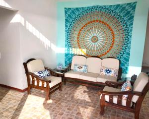una sala de estar con 2 sillas y una pintura en la pared en Casuarinas Del Mar Hospedaje Chalet 3 habitaciones, en Canoas