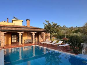 a swimming pool with chairs and a house at Villa Pool & Sun Durrës in Durrës