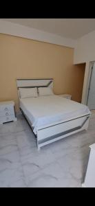 a bedroom with a large white bed and a tiled floor at Hotel y Villa Marchena in Azua de Compostela