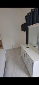 Habitación blanca con mesa y espejo. en Hotel y Villa Marchena en Azua de Compostela