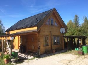 una pequeña casa de madera con techo de gambrel en Faakersee - Familyhouse - mit PrivatStrand- Only Sa-Sa, en Egg am Faaker See