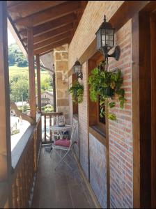 un porche con una mesa y algunas plantas y luces en Casa restaurada en pequeño pueblo de montaña, en Pujayo