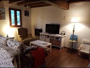 uma sala de estar com um sofá e uma televisão de ecrã plano em Casa restaurada en pequeño pueblo de montaña em Pujayo