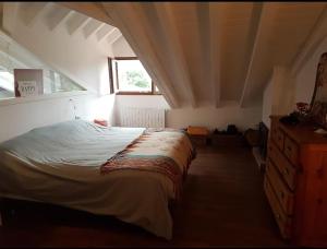 a bedroom with a bed and a dresser and a window at Casa restaurada en pequeño pueblo de montaña in Pujayo