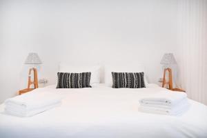 ein Schlafzimmer mit einem weißen Bett mit zwei Kissen in der Unterkunft New Day by HolyGuest in Tel Aviv