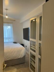 a bedroom with a bed and a flat screen tv at STARS LUXURY HOME in London