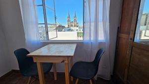 uma mesa e duas cadeiras em frente a uma janela em La Merced em Salta