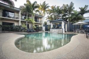 a swimming pool in front of a building at Coral Cay Resort in Mackay