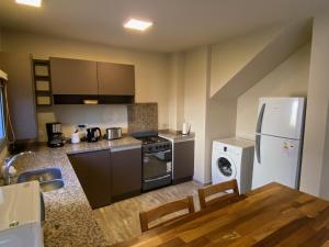 a kitchen with a stove and a refrigerator and a table at Baita Di Franca in Córdoba