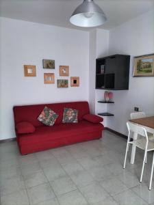 sala de estar con sofá rojo y mesa en Daro's apartment, en Selargius