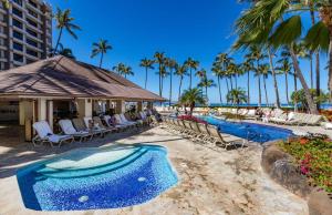 a resort with a pool and chairs and palm trees at The Kaanapali Alii By Maui Resort Rentals in Lahaina