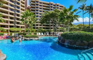 a pool at a resort with people in it at The Kaanapali Alii By Maui Resort Rentals in Lahaina