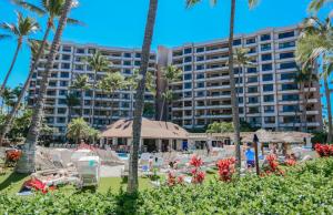 um resort com palmeiras e cadeiras e um hotel em The Kaanapali Alii By Maui Resort Rentals em Lahaina