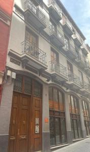 un edificio con puertas y ventanas de madera en una calle en ILBIRA, en Granada