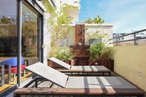 een patio met banken en tafels op een balkon bij Colorful Shenkin 3-BR by HolyGuest in Tel Aviv