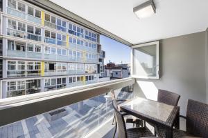 een balkon met een tafel en stoelen en een gebouw bij iStay Precinct Adelaide in Adelaide