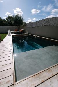 - une piscine dans un jardin avec une terrasse en bois dans l'établissement Bright Contemporary House - Private Pool, à LʼIsle-sur-la-Sorgue