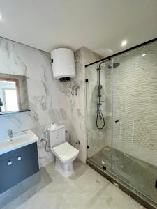 uma casa de banho com um chuveiro, um WC e um lavatório. em Appartement haut standing proche Océan em Salé