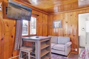a living room with a table and a chair and a tv at Big Pines Couple Lakeview Studio Cabin by Big Bear Vacations in Big Bear Lake