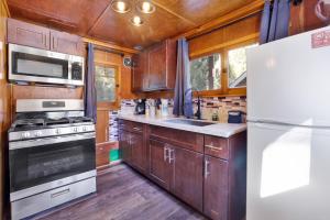 a kitchen with wooden cabinets and a white refrigerator at Big Pines Couple Lakeview Studio Cabin by Big Bear Vacations in Big Bear Lake