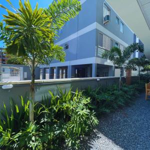a building with a palm tree in front of it at Residencial Alianza - Departamento de 1 habitación 204 in Bombinhas