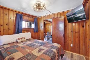 a bedroom with a bed in a room with wooden walls at Lakeview Family Cabin by Big Bear Vacations in Big Bear Lake