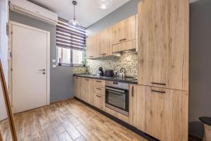 a kitchen with wooden cabinets and a door at One Bedroom Apt - Close to Valletta in Hamrun