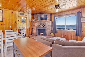 a living room with a fireplace and a table and chairs at Sunrise Lakefront Family Cabin by Big Bear Vacations in Big Bear Lake